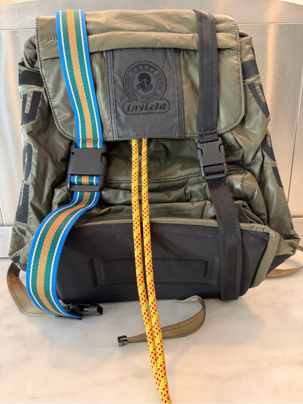 Invicta Olive Green Backpack with Striped Blue Strap and Yellow Drawcords